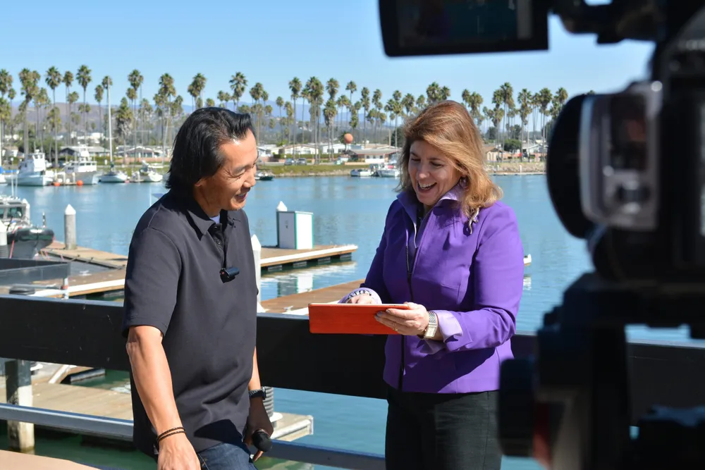 Heidi Berenson conducting an on-camera interview by the water