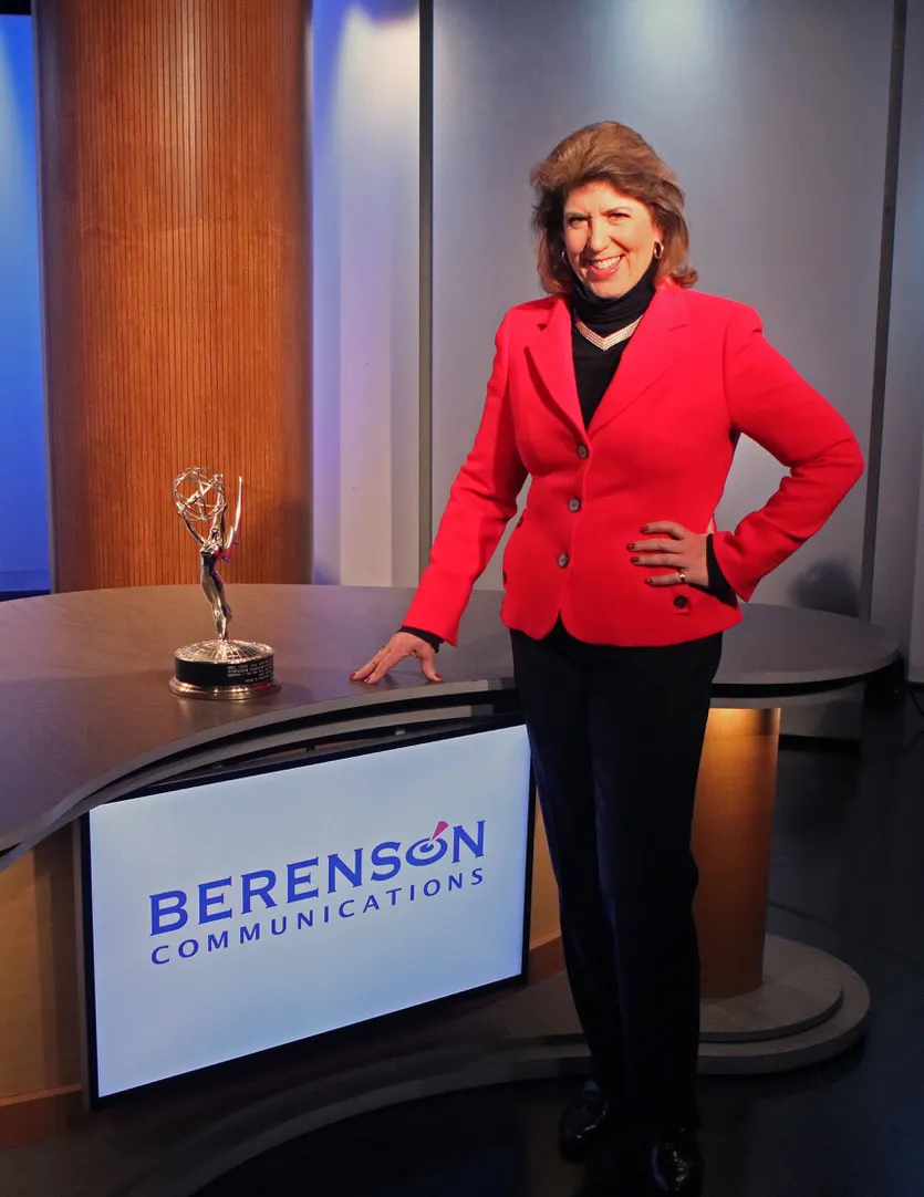 Heidi Berenson in a TV studio beside her Emmy Award
